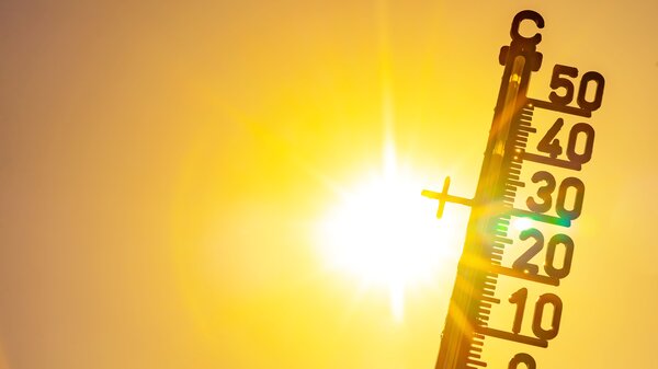 Bild vergr&ouml;&szlig;ern: Heißes Wetter – Hitzewelle / Sommerhitze im Hintergrund – Thermometer, gelb-orangefarbener Himmel und Sonnenstrahlen