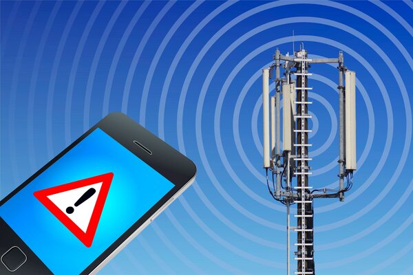 Bild vergr&ouml;&szlig;ern: Handy mit Warnsignal auf Bildschirm im Schallkreis einer Sirene